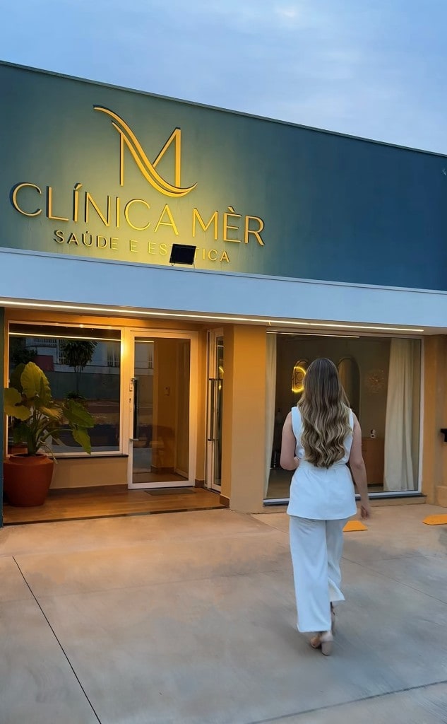 Entrada da clínica ao entardecer com iluminação elegante.